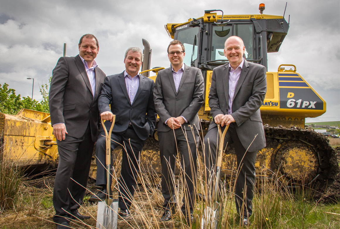image of four wcctv directors in front of a bulldozer at the site of their new premises